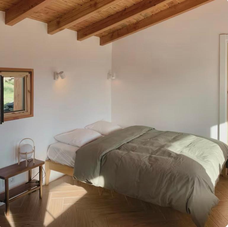 エアにあるSan Bartolomé Etxolaの白いベッドルーム(ベッド1台、テーブル付)