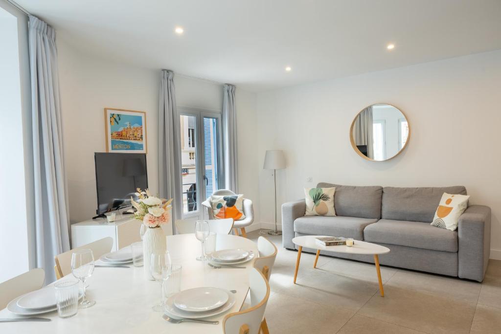 un salon avec une table et un canapé dans l'établissement République Appartements, à Menton