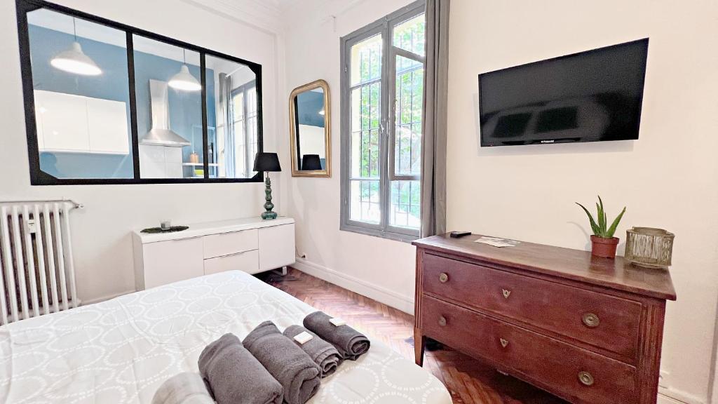 une chambre avec un lit et une télévision au mur dans l'établissement Le Palais Jean, à Nice