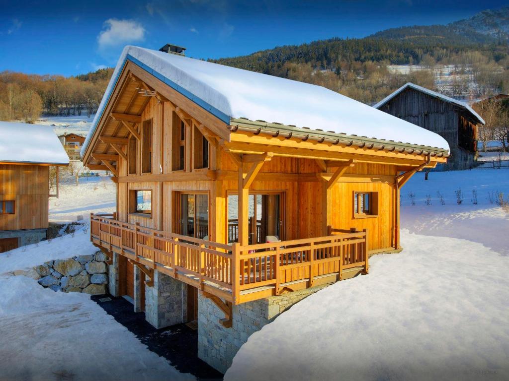 une cabane en rondins avec de la neige sur le toit dans l'établissement Chalet Pajules - OVO Network, à Le Fey
