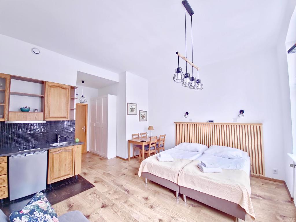 a bedroom with a bed and a kitchen with a table at Apartamenty Velvet in Poznań