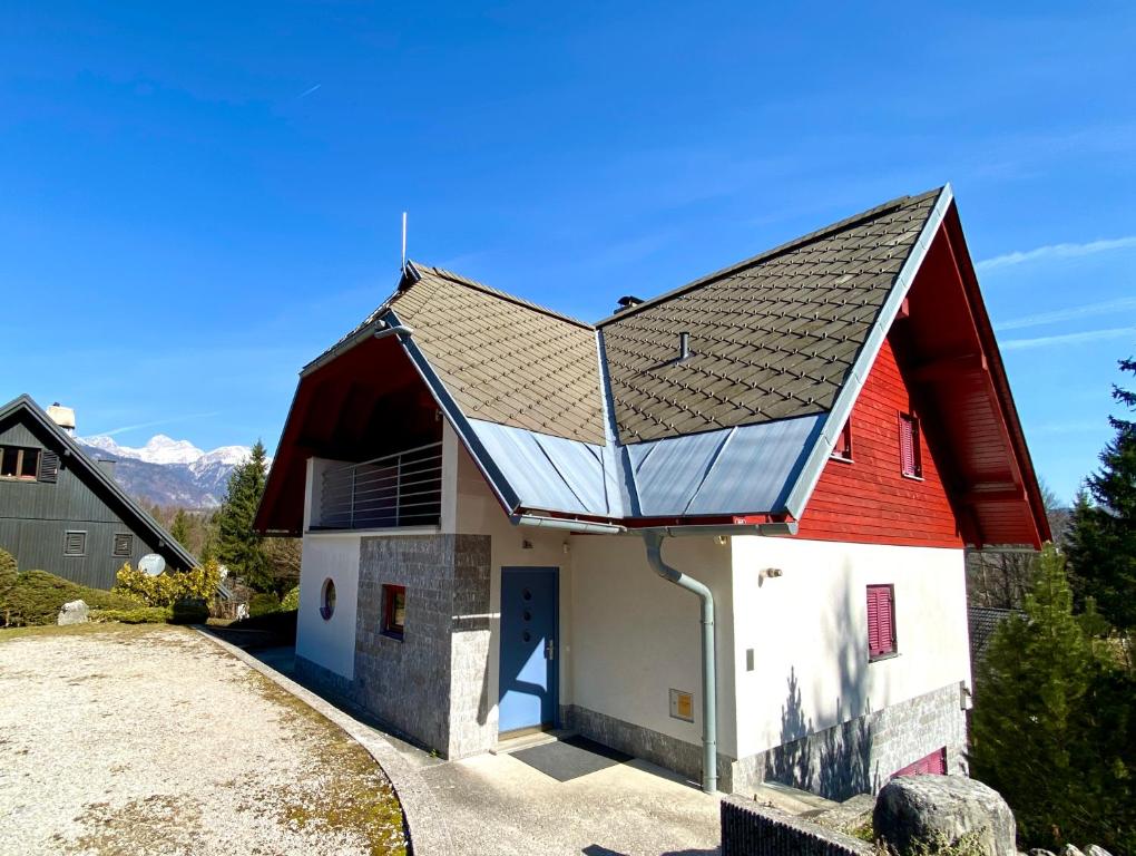 a red and white barn with a red roof at Bohinj Cozy Escape Holiday Home in Bohinj