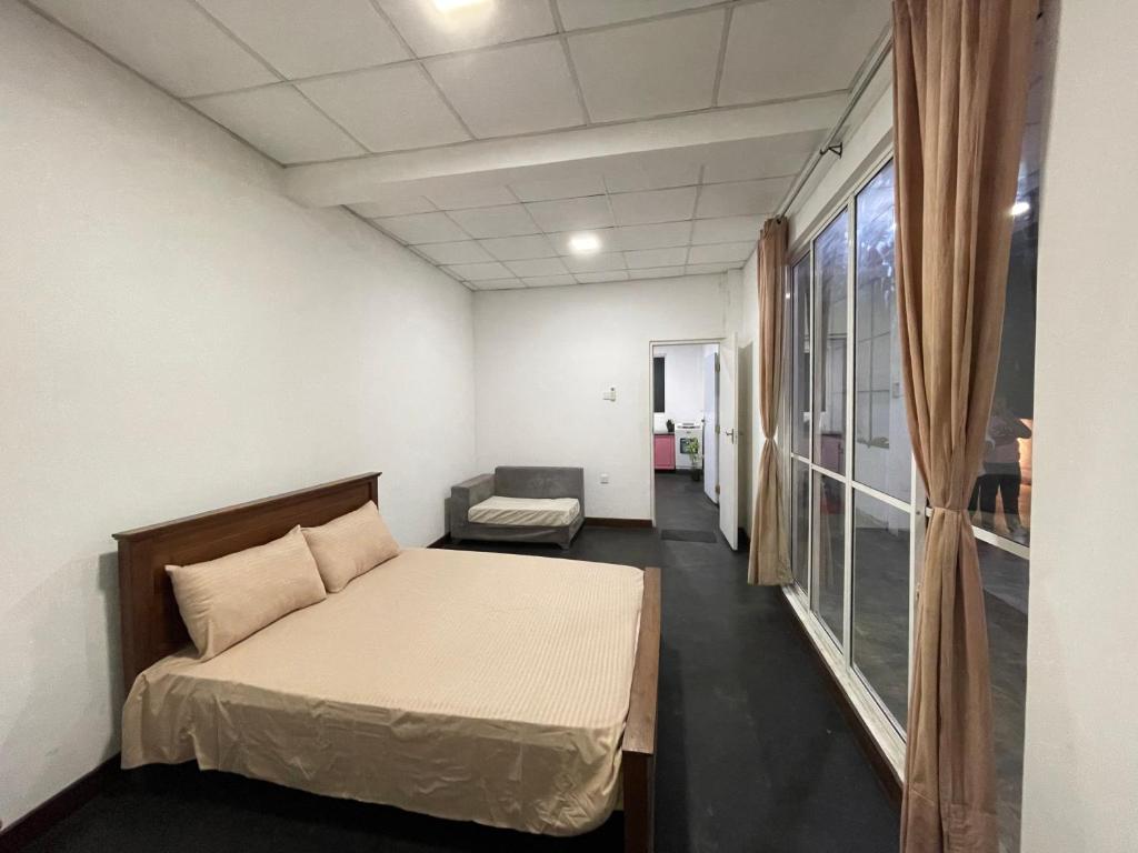 a room with a bed and a couch and a window at Misty Mountain Lodge in Kegalle