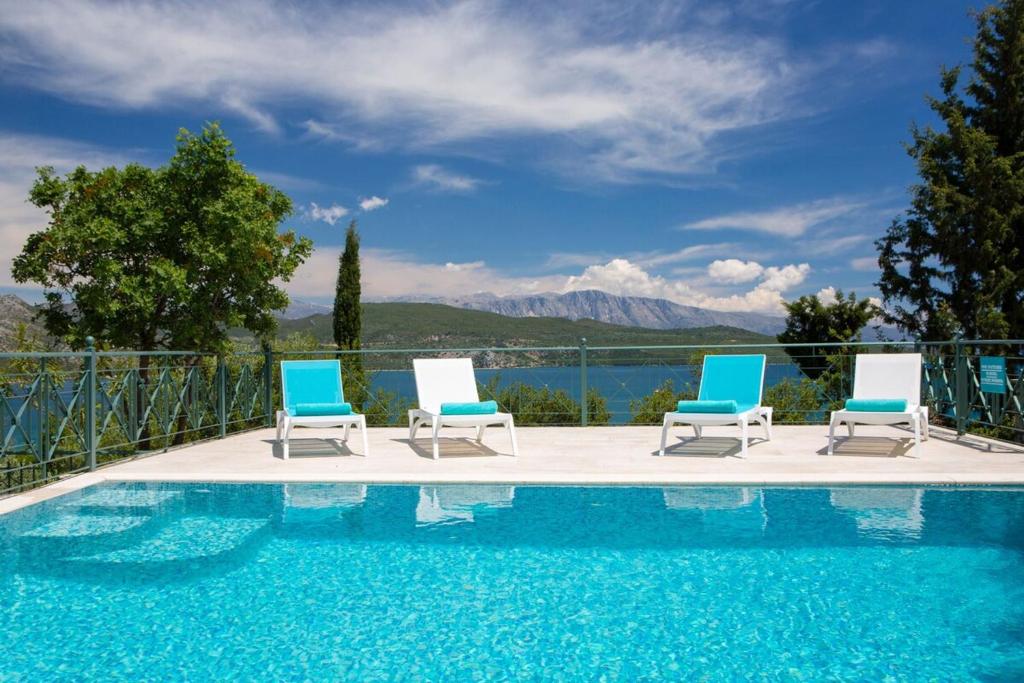 a group of chairs sitting next to a swimming pool at Buena Vista Villa - Amazing sea view in Lygia