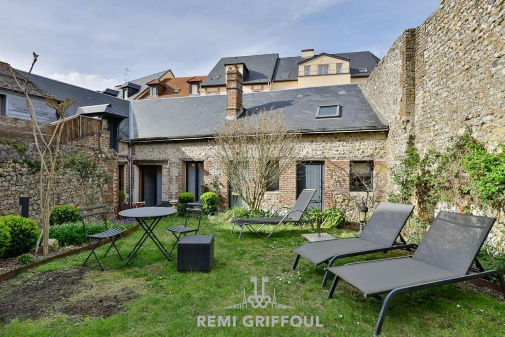 une cour avec des chaises et une table ainsi qu'un bâtiment dans l'établissement La Maison du Jardin City Center 5 guests, à Honfleur