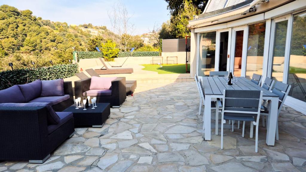 une terrasse avec des canapés, une table et des chaises dans l'établissement Maison avec grande terrasse sur Nice, à Nice