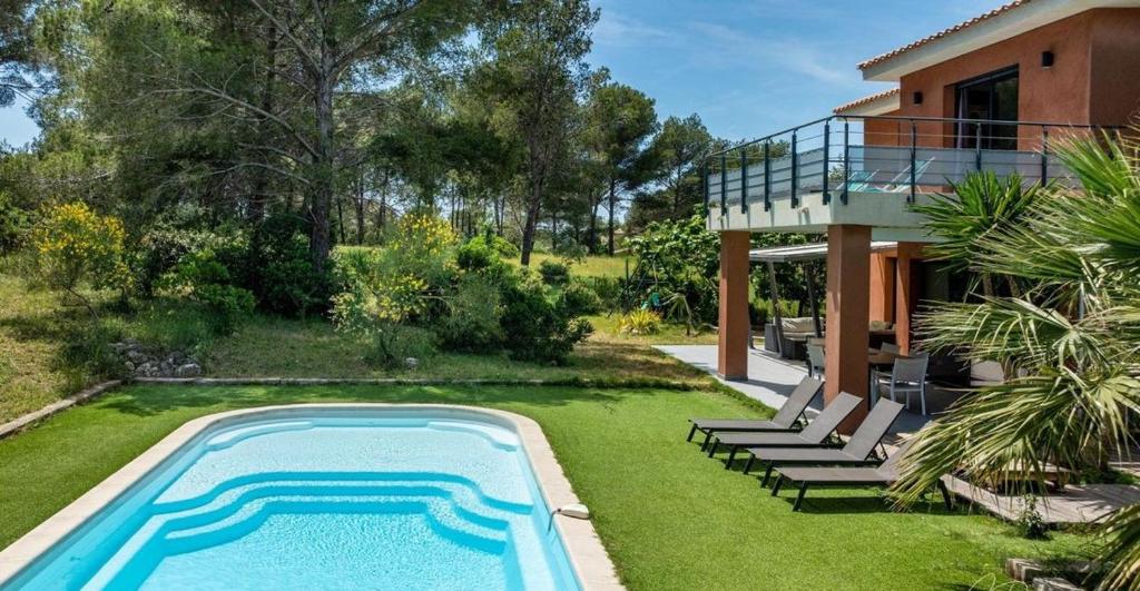 une maison avec une piscine dans la cour dans l'établissement Villa Cap Dramont, à Saint-Raphaël