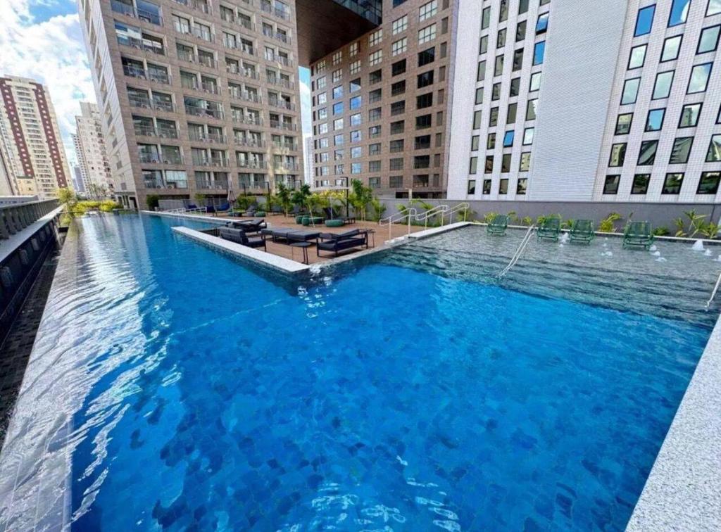 a large swimming pool in a city with tall buildings at Apartamento São Paulo Tatuapé in Sao Paulo