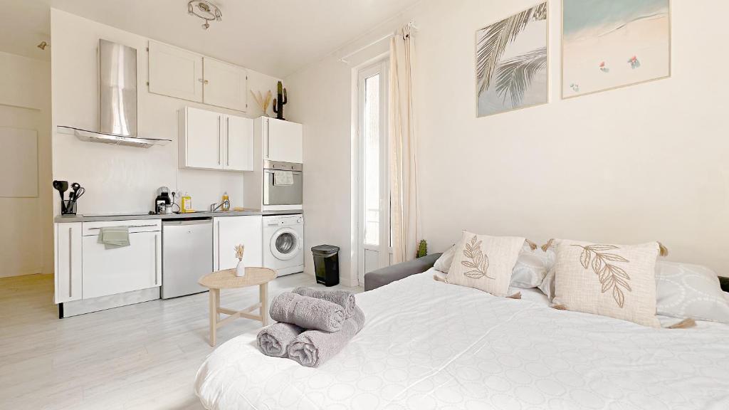 une chambre blanche avec un lit et une cuisine dans l'établissement La Bella Niçoise, à Nice