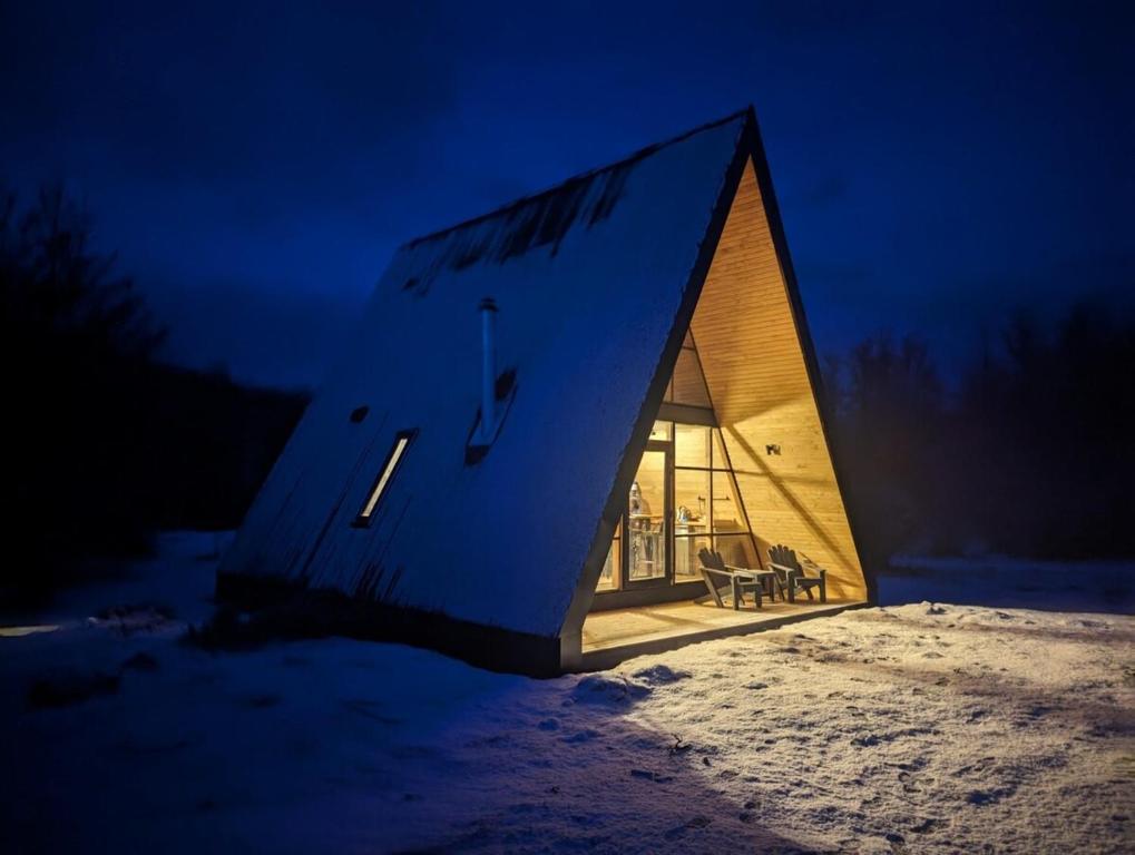 OUTSCAPE l Preciosa Cabaña en Villa Castillo في فيلا سيرو كاستيلو: منزل صغير مضاء بالليل