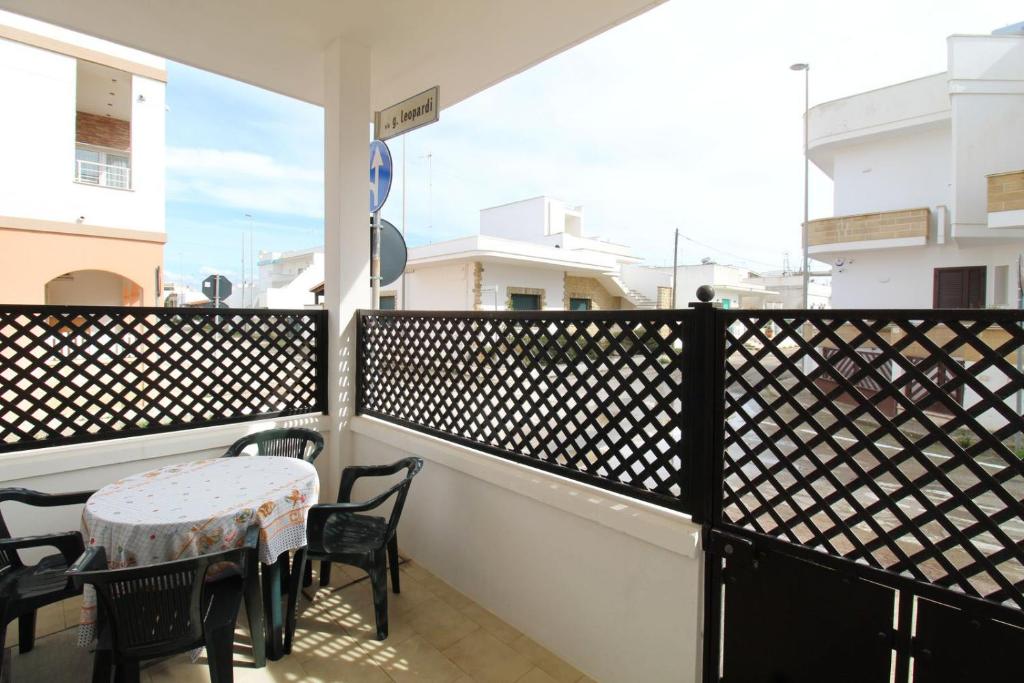 a balcony with a table and chairs and a window at Casa vacanze LuGi by Apulia home in Torre San Giovanni Ugento