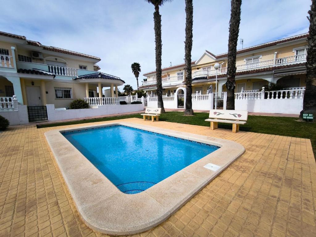 a swimming pool in front of a house at Bungalow Malibu Complex Doa Pepa- Rojales in Ciudad Quesada