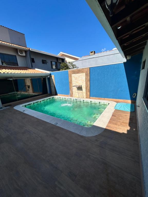 a swimming pool on the side of a house at Sobrado, 4 Quartos, Piscina, até 12 pessoas in Foz do Iguaçu