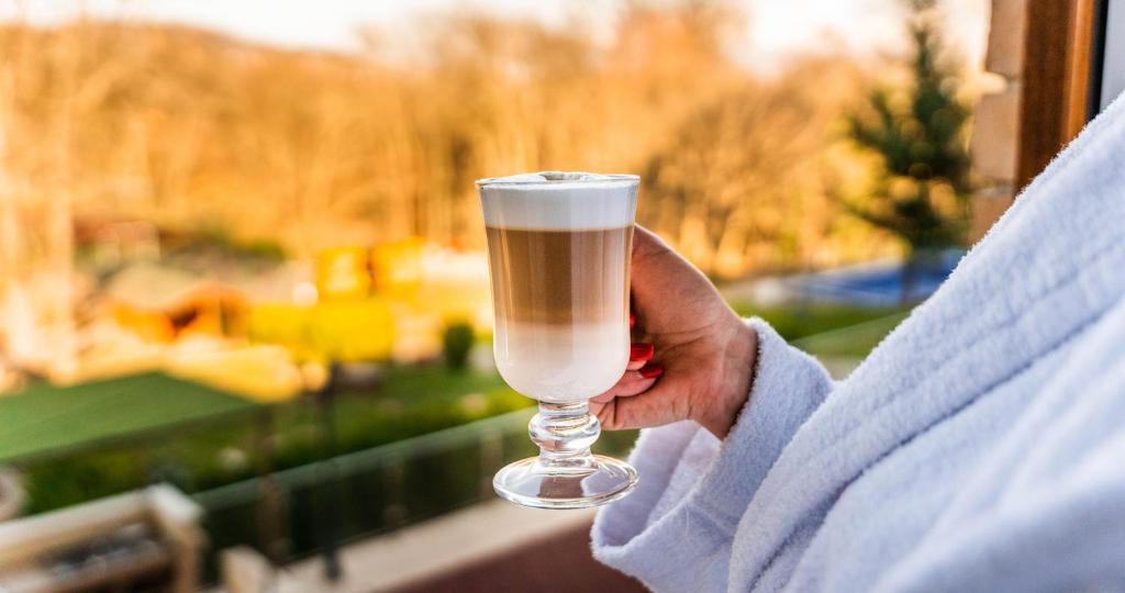 a person holding up a glass of champagne at The Hotel Unforgettable - Hotel Tiliana by Homoky Hotels & Spa in Budapest