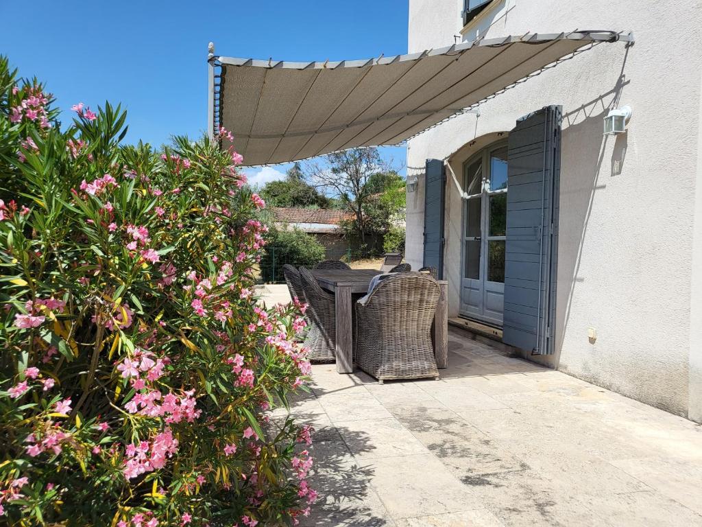 a patio with a table and chairs under an umbrella at Villa Doce Lar in Lioux