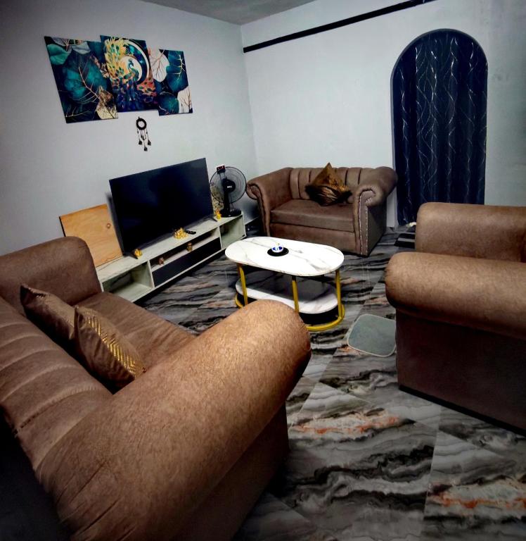 a living room with two couches and a tv at Sun & Moon Homestay in Port Dickson