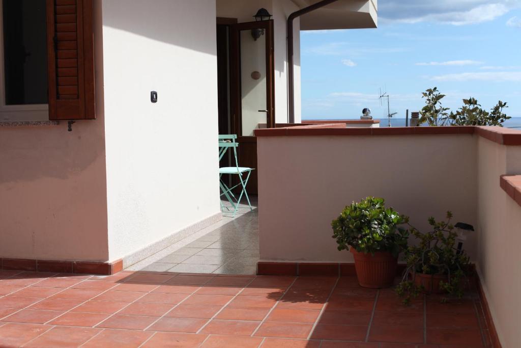 a balcony of a house with a view of the ocean at Casa delle Rose Terrazza vista mare panoramica e relax a Cala Gonnone, WiFi, AC in Cala Gonone