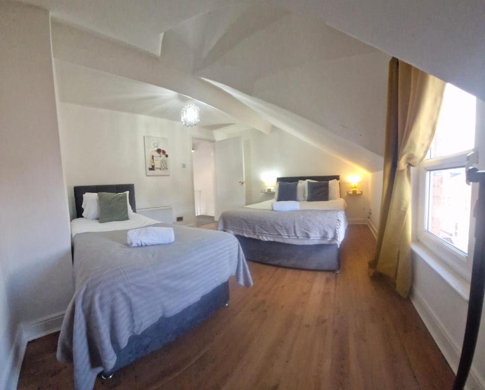 a room with two beds and a window at 4br House Popular Ravenhill Road in Belfast