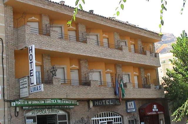 un grand bâtiment en briques avec un hôtel dans l'établissement Hotel Limas, à Cazorla