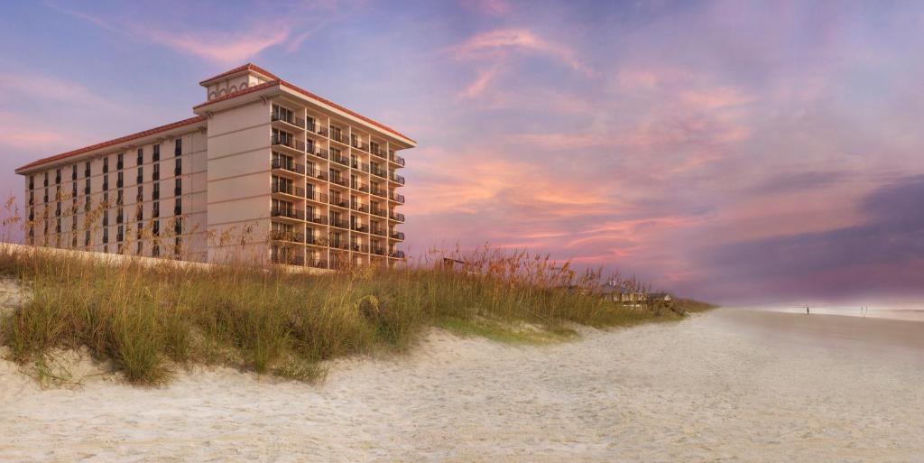 un edificio en la playa junto a una playa de arena en One Ocean Resort and Spa, en Atlantic Beach