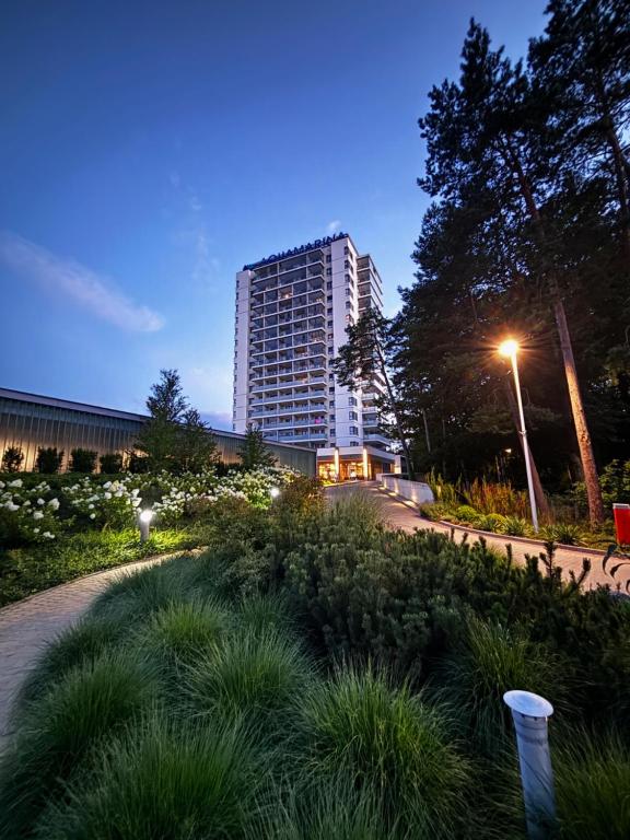 ein hohes Gebäude mit Straßenlicht und Gras in der Unterkunft Aquamarina Onyx Marina Invest in Misdroy
