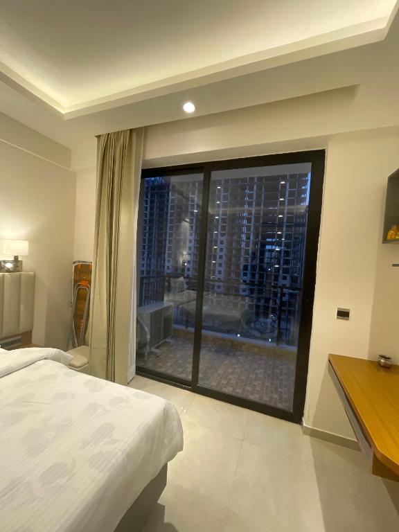 Un dormitorio con una gran ventana con vista a una ciudad. en Regal stay, en Lucknow