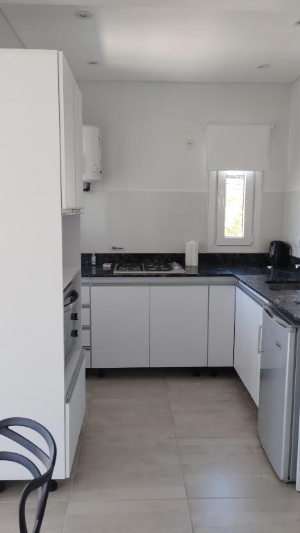 a white kitchen with white cabinets and a window at Estudio Urbano in Santa Rosa