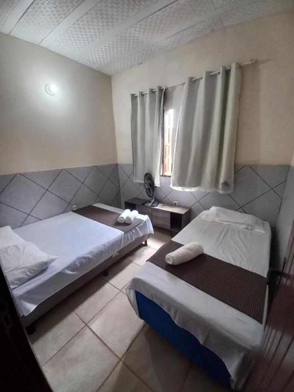 Una habitación de hotel con dos camas y una ventana. en EcoCasa Rio Sauípe 200 m da Praia, en Porto de Sauipe