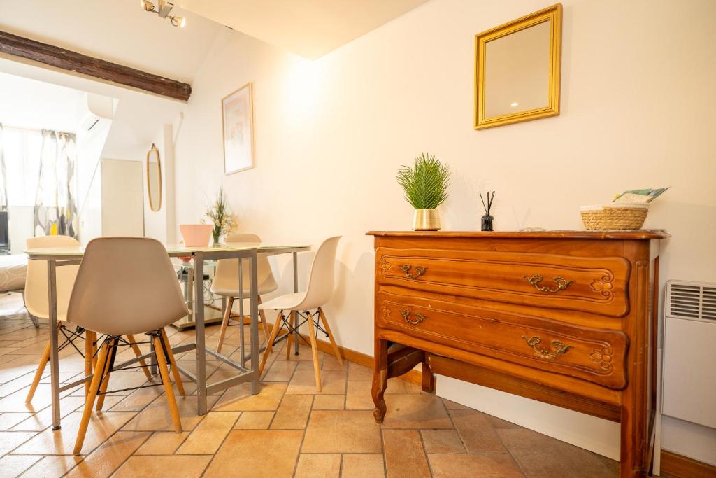 Cette chambre comprend une commode et une table avec des chaises. dans l'établissement Le Golden City, à Nice