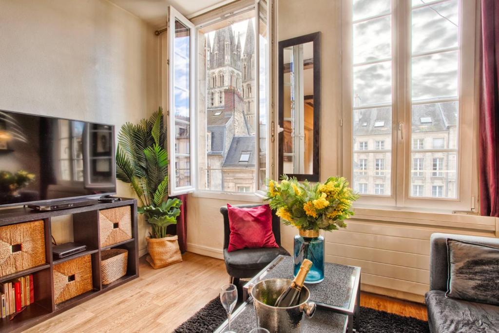 un salon avec un canapé et une table dans l'établissement La Casa Bella — Parking privé & vue sur l'abbaye, à Caen