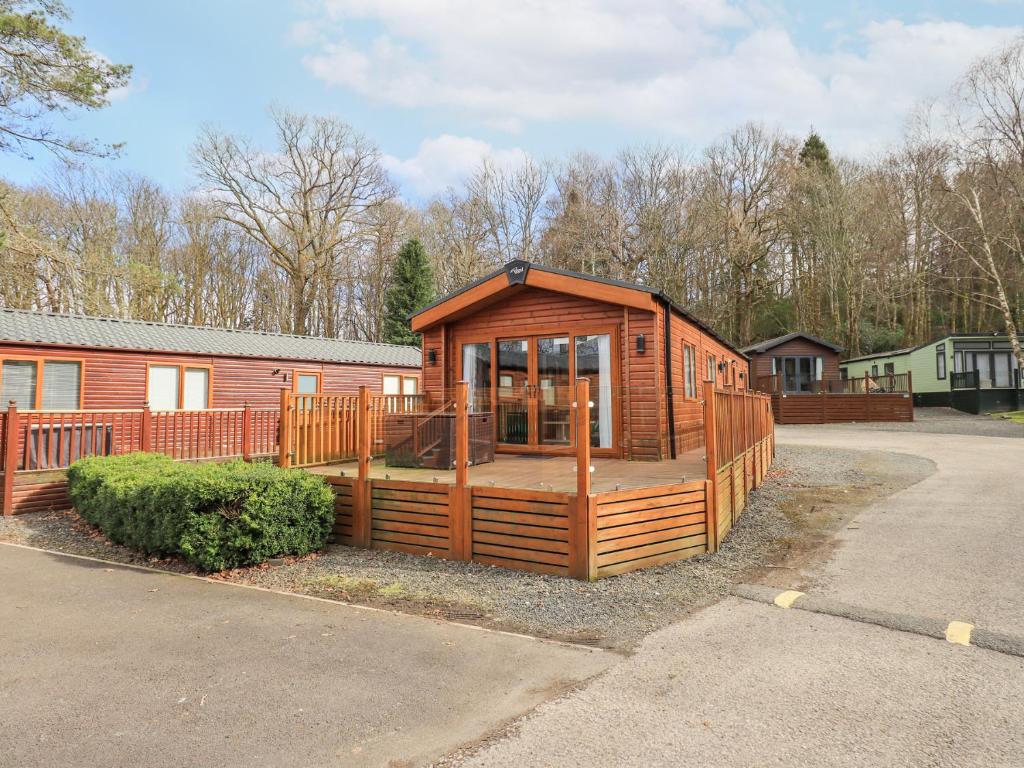 une cabane en bois avec une terrasse dans un parking dans l'établissement Windermere View, à Windermere
