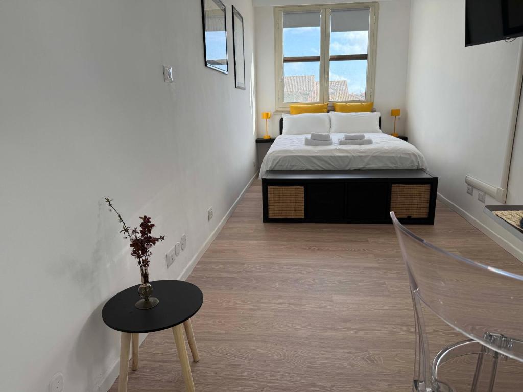 a bedroom with a bed and a table and a chair at Maison Circe - Boutique Apartment in Latina