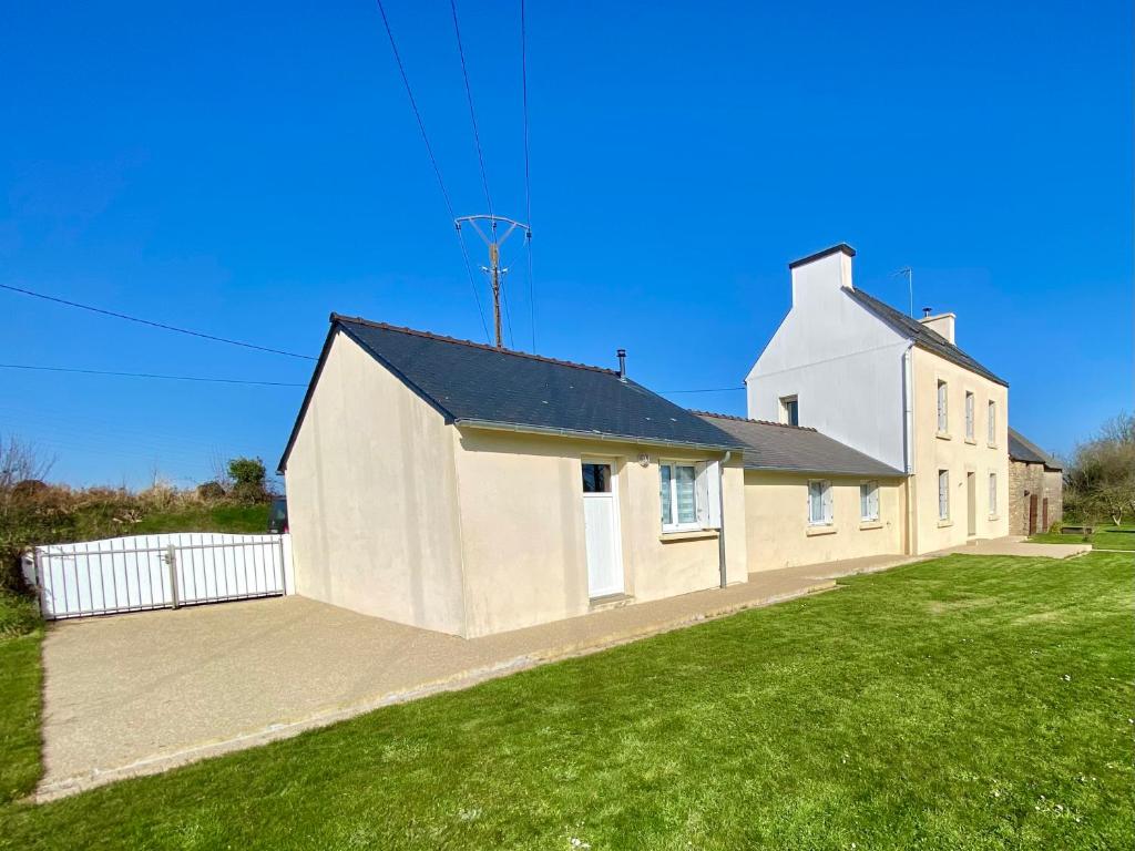 a large white house with a large grass yard at Maison à la Campagne à Melgven in Melgven