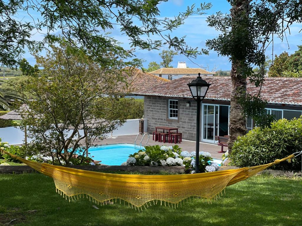 - un hamac jaune dans la cour d'une maison dans l'établissement Cozy Cottage, à Praia da Vitória