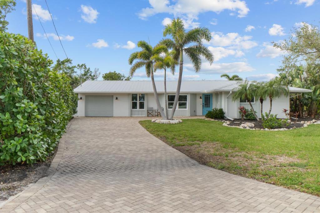a house with palm trees and a driveway at Blue Ibis in Sanibel