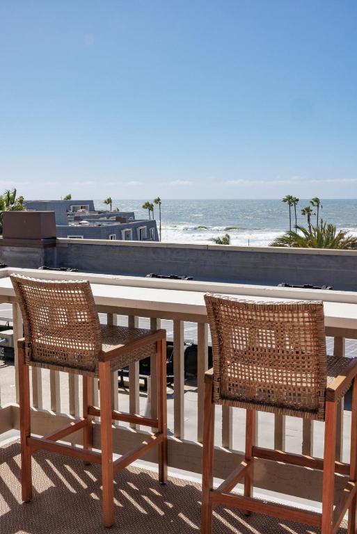 two chairs and a table on a balcony overlooking the ocean at B304 - The Lookout in Oceanside