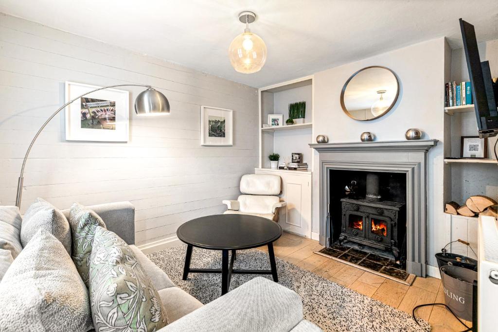 ein Wohnzimmer mit Sofa und Kamin in der Unterkunft Mills Cottage - 1 parking space in Henley on Thames