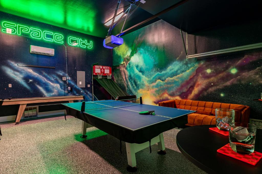 a ping pong table in a room with a space shuttle mural at Space City - Prof Design, Game Room, King BD in Houston