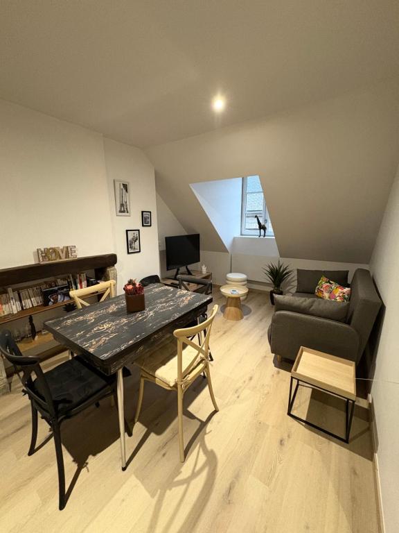 a living room with a table and a couch at La Villa Louana 4 Appartement neuf et moderne tout confort in Aubusson