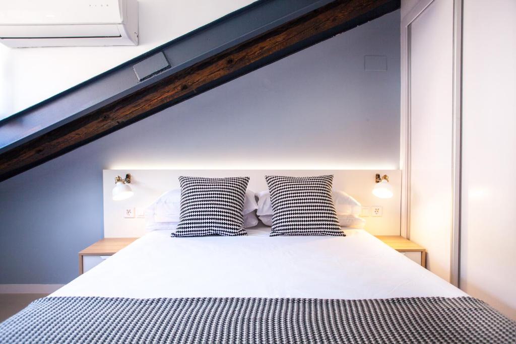 a bed with two black and white pillows on it at Apartment in Malasaña in Madrid