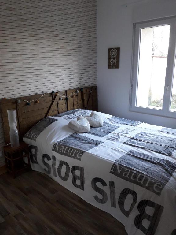 une chambre avec un lit avec deux oreillers dessus dans l'établissement Petit nid ,1 km du zoo,au calme,détente assurée, à Seigy