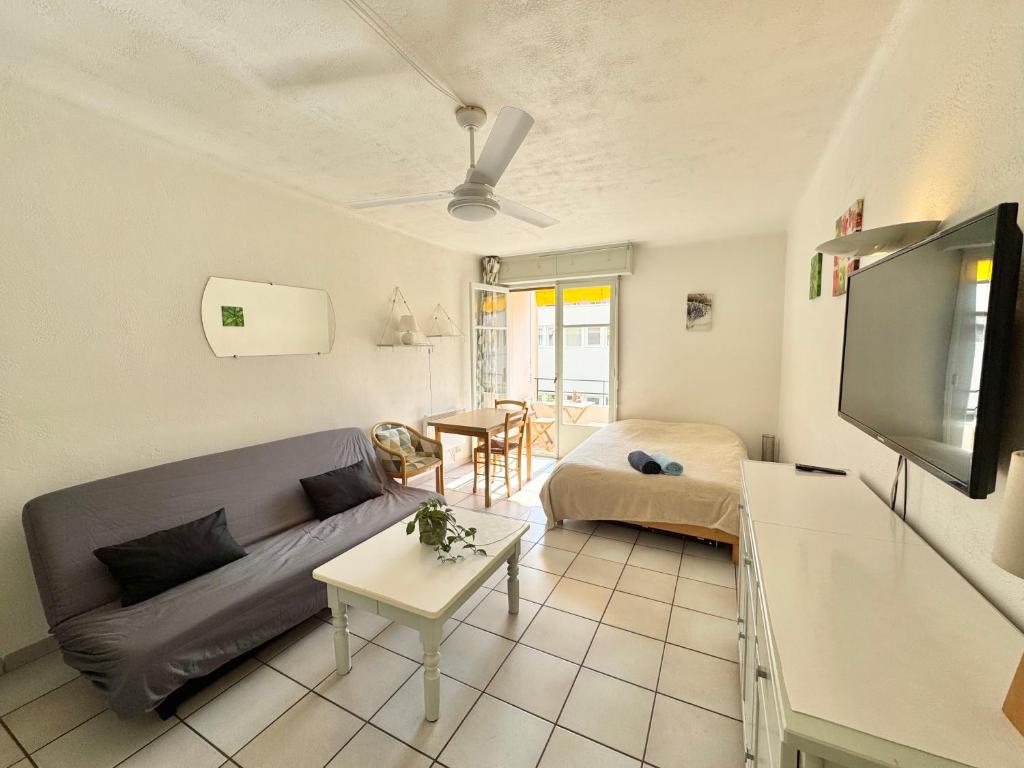 un salon avec un canapé et une télévision dans l'établissement L'helios studio au calme centre et mer, à Vallauris