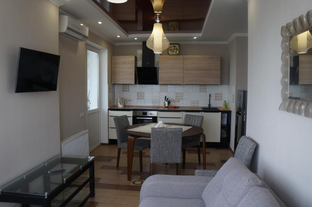 een keuken en een woonkamer met een tafel en een bank bij Apartment on Pozhyaki in Kiev