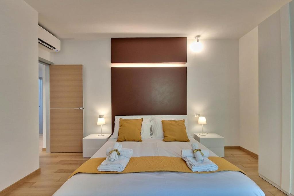 a bedroom with a large bed with towels on it at Double Sea View Design Wi-Fi Parking AC in Fermo