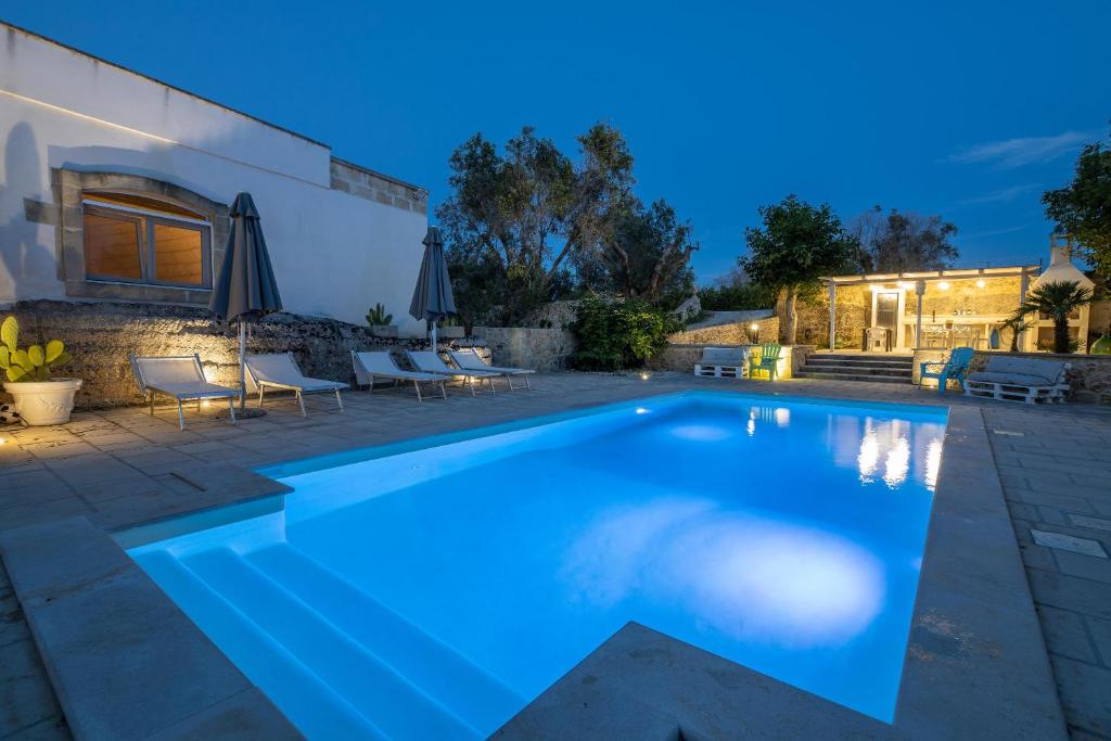 a swimming pool in a backyard at night at Villa Enea in Poggiardo