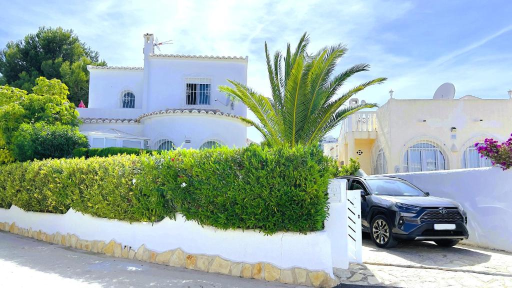 a car parked in front of a white house at Casa Lima Mediterránea in Benitachell