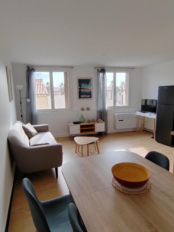 a living room with a couch and a table at Beau T3 coeur village in Gruissan