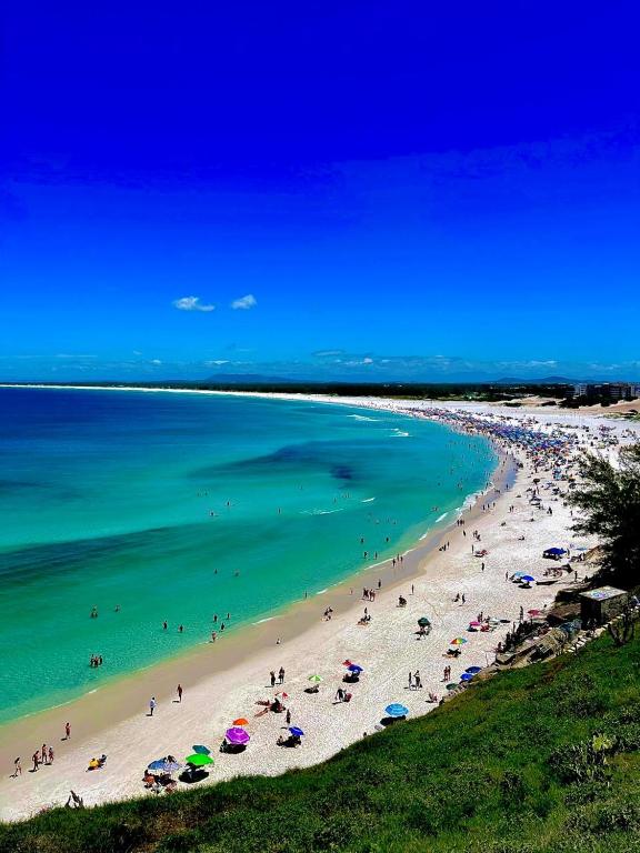 plaża z ludźmi i parasolami w wodzie w obiekcie Aluguel de Apartamento em Cabo Frio Temporada e Finais de Semana w mieście Cabo Frio
