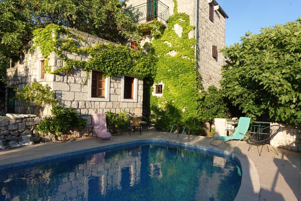 a swimming pool in front of a building at Holiday home Villa Kastel in Korčula