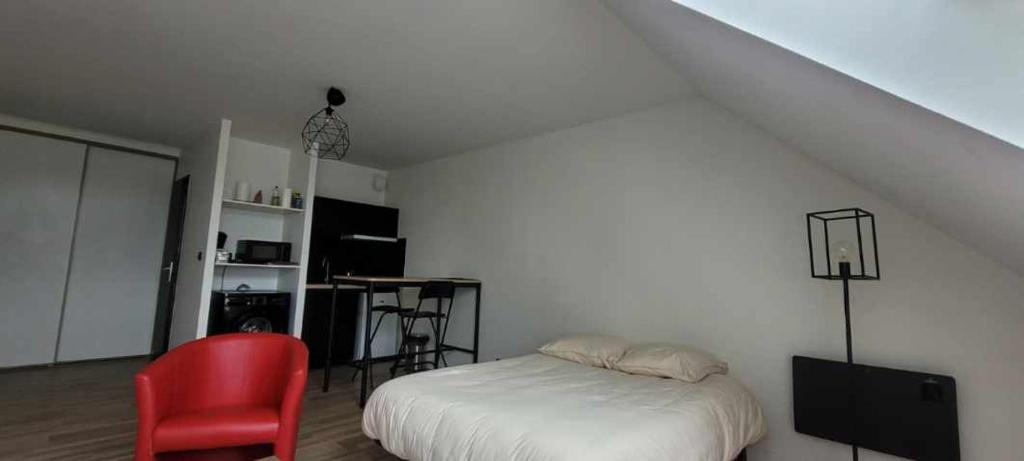 a bedroom with a bed and a red chair at Studio Blain centre ville in Blain